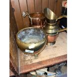 A twin handled copper canister, a brass and copper jug, and a brass three footed bowl