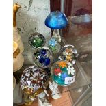 A collection of six glass paperweights, assorted makers, together with a Heron glass mushroom.