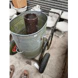 A galvanised bin on a trolley together with a earthenware drain pipe.