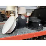Two silk top hats, a bowler hat and a policeman helmet.