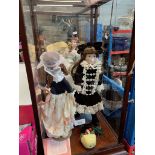 Two perspex display cases with 3 dolls.