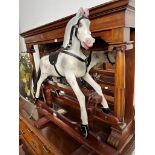 A vintage dapple grey rocking horse with leather saddle and reins, length 89cm, height to saddle