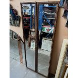 A pair of full length wall hanging mirrors.