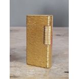 A vintage Dunhill gold plated textured lighter.