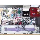 A tray of assorted costume jewellery including charm bracelets, hematite beaded jewellery etc.