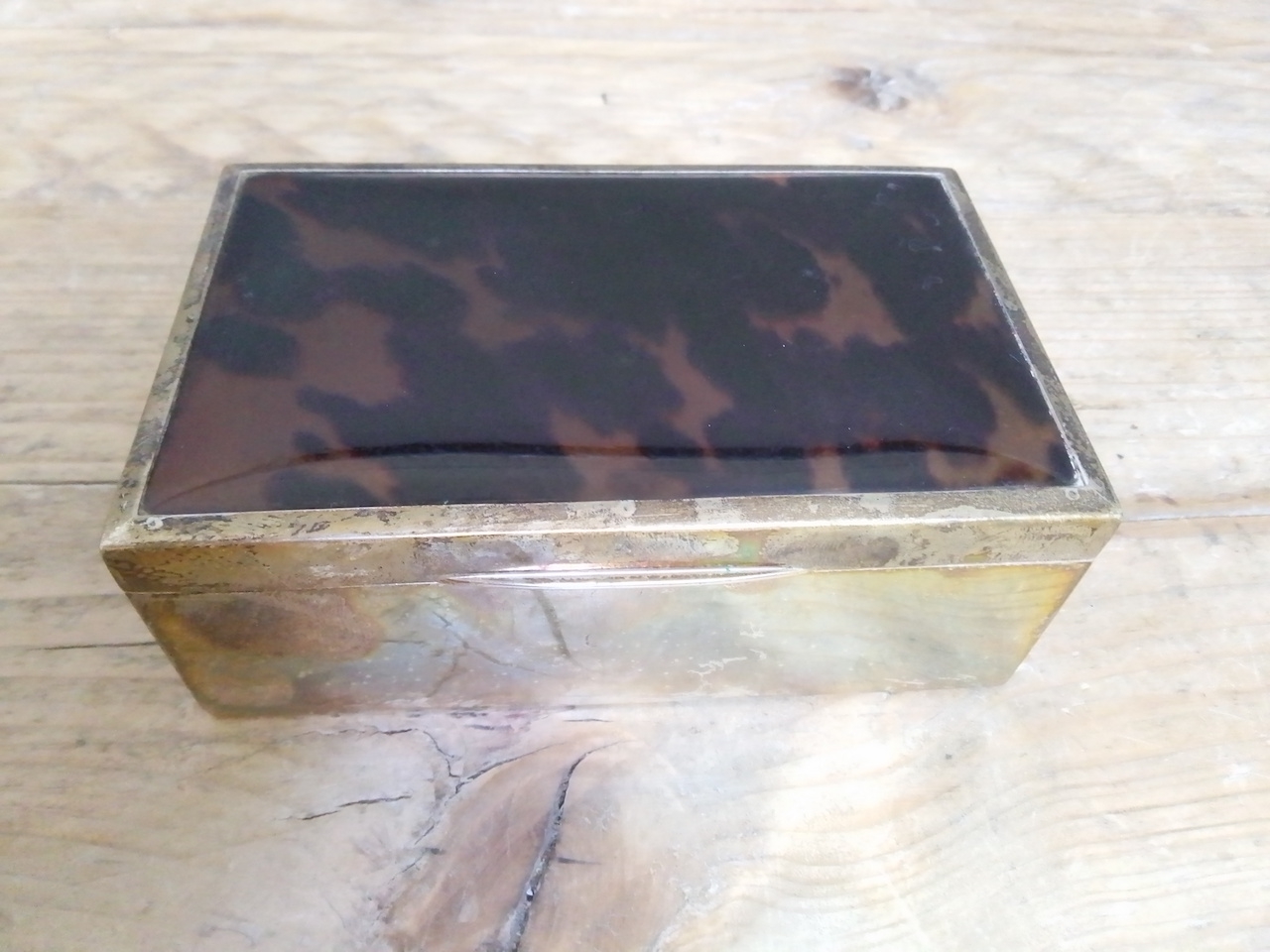 A George V silver and tortoiseshell cigarette box, Adie Brothers, Birmingham 1923, length 14cm.