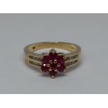 A ruby and diamond cluster ring, makred '9k', gross wt. 2.2g, size K.