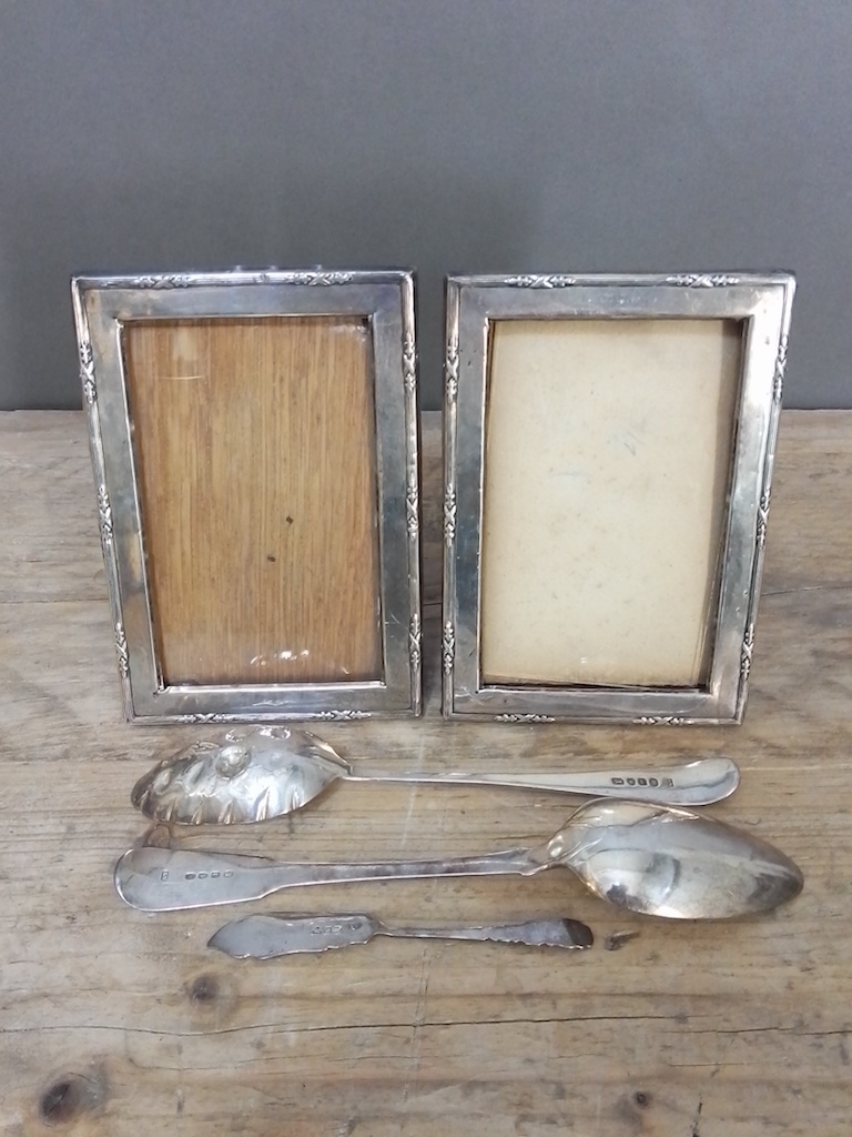 A mixed lot of hallmarked silver comprising a pair of photo frames, a 'berry' spoon, another