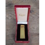 A vintage Cartier gold plated textured lighter in box.