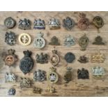 A collection of military cap badges and plates to include Manchester Regiment, 33rd Lancashire