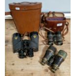 Three pairs of vintage binoculars, one WWII Canadian and two WWI era.