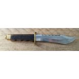 A fixed blade bowie knife with wooden handle, brass guard and pommel, marked on blade 440 Stainless.