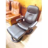 An Ekornes Stressless black leather reclining and swivel lounge chair with matching stool.