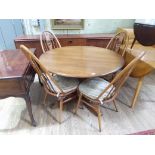 An Ercol extending pedestal table and four chairs.