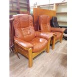 A pair of modern Ekornes Stressless tan leather reclining armchairs.