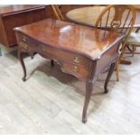 A George III bow front mahogany dressing table, in the French taste with shaped top, three