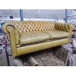 A mustard leather chesterfield settee.