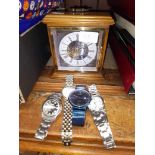Four gents wristwatches and a German clock.