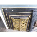 A 19th century fire surround with pierced brass hinged doors.