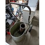 A galvanised bin on a trolley together with a earthenware drain pipe.