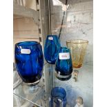 Four Whitefriars glass vases, three blue including dimple vase and one amber.