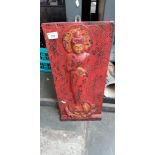 A wooden Oriental plaque depicting a deity.