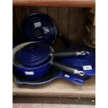 A set of blue Le Creuset pans; 3 graduated pans and a griddle pan.