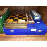 A vintage carved stone chess set together with a set of dominoes, dominoes score board and another