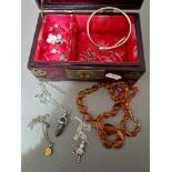 A oriental style wood and brass box with jade insert and contents including an amber necklace...