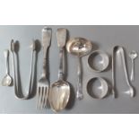 A mixed lot of silver items including, a strainer ladle, two napkin rings, spoon, fork, tongs,