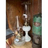 A milk glass lamp with brass fitting and funnel together with a cut glass lamp with funnel.
