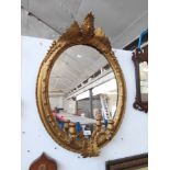 A 19th century oval gilt swept mirror with candle sconces 57cm x 81cm.