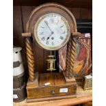 A vintage clock, with enamelled face, on twist columns, with low tray and key.