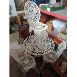 A cast metal garden table and four chairs.