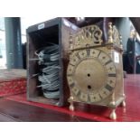 A brass lantern clock case and a box of wires.