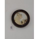 A miniature embroidery depicting a female figure in side profile, glazed and framed, diameter 15.