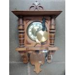 A German walnut cased wall clock with pendulum and key.