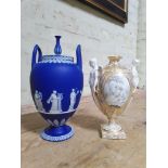 Two porcelain urns comprising a Wedgwood Jasper ware twin handled and lidded pedestal urn