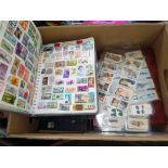 A box of assorted stamp albums and cigarette cards.