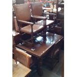 An aged oak extending dining table with six oak and studded leather chairs including three carvers.