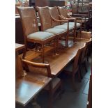 An extending dining table and ten cane back chairs including two carvers, length 244.5cm, width 94.