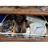 A metal basket containing various clocks, desk clocks, stop clocks, etc.