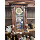 A wall clock with pendulum and key.