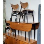 A mid 20th century G Plan ebonised and tola drop leaf table and four chairs, designed by E Gomme.