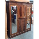 An Edwardian inlaid mahogany fitted wardrobe with mirrored doors and drawers to centre, width 195cm.