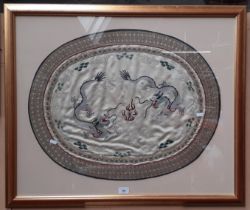 A Chinese embroidered silk textile depicting dragons, framed and glazed, 88cm x 73.5cm.