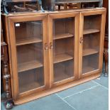 An Ercol elm glazed bookcase, height 97cm, width 136cm and depth 29cm.