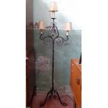 A wrought metal floor lamp with brass bell.