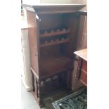 An aged oak wine cabinet with glazed doors and a single drawer.