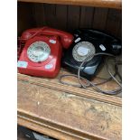 2 vintage telephones, one red and one black.